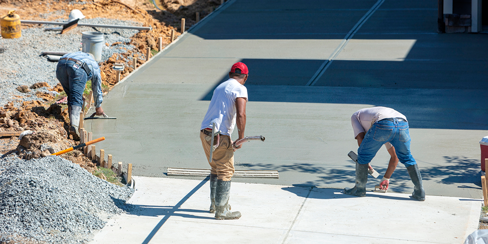 Workers lay concrete at a new facility.
